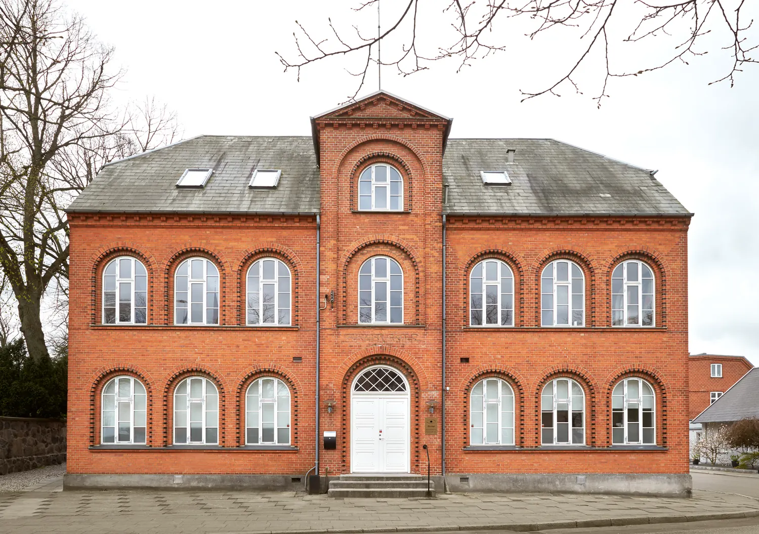 Foreningshuset set forfra — den store røde murstensbygning rummer både høreklinik og øjenklinik.